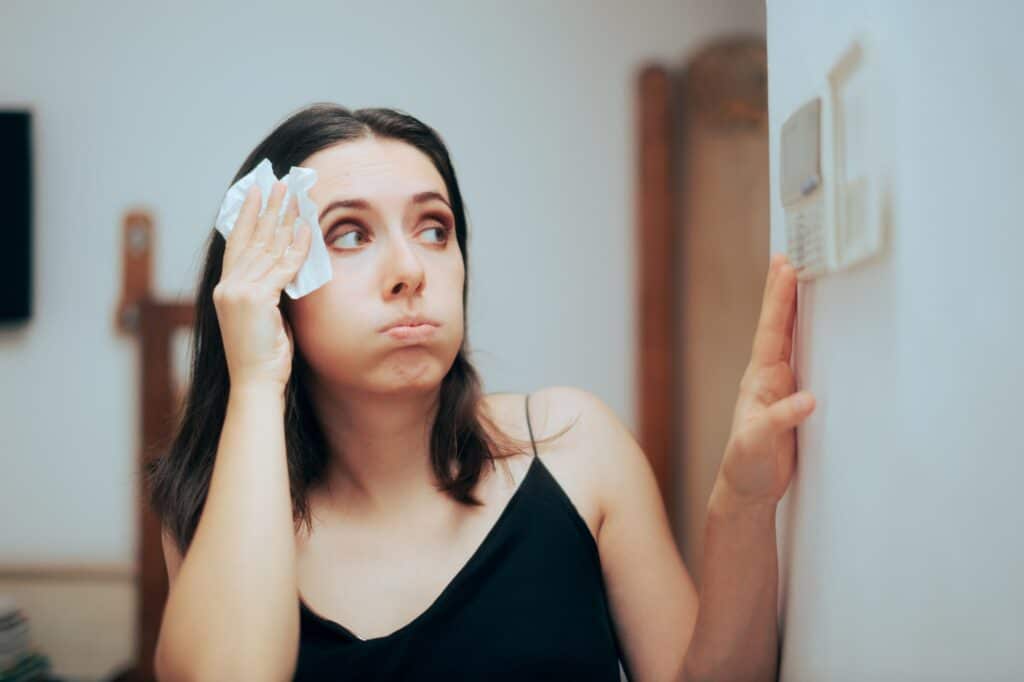 woman wiping sweat due to air conditioning problems