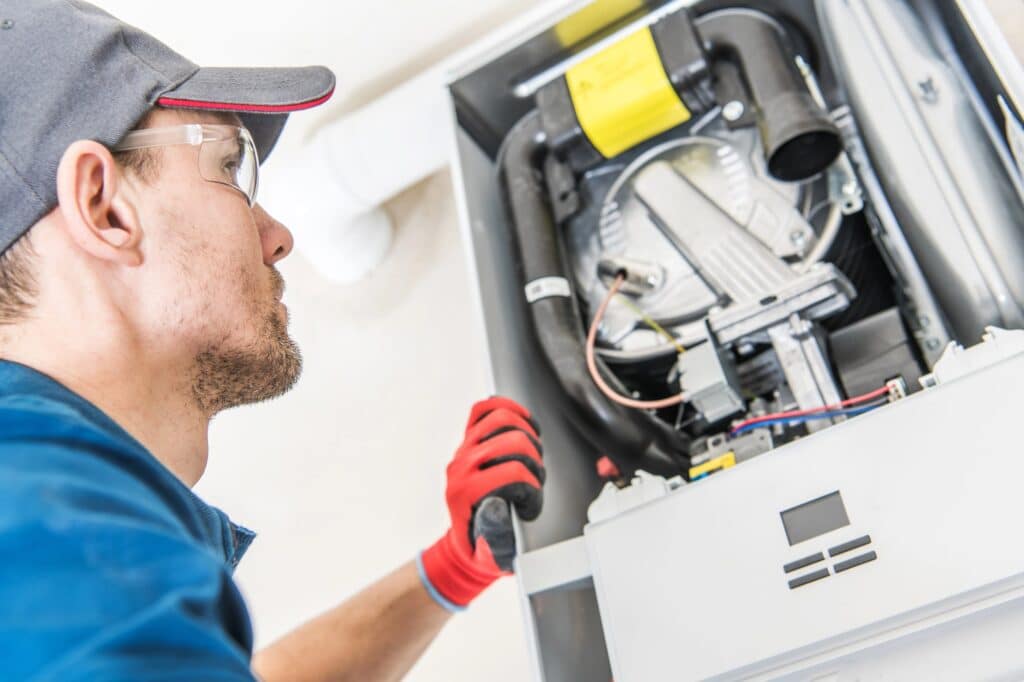 hvac technician checking furnace heating system